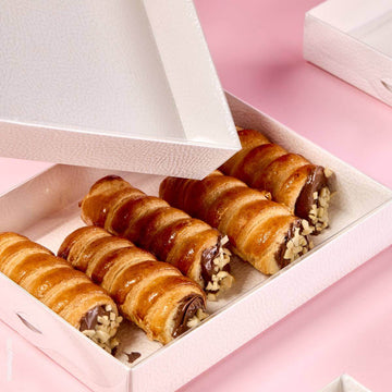 Scatola per alimenti bianca con coperchio trasparente contiene cannoli dolci